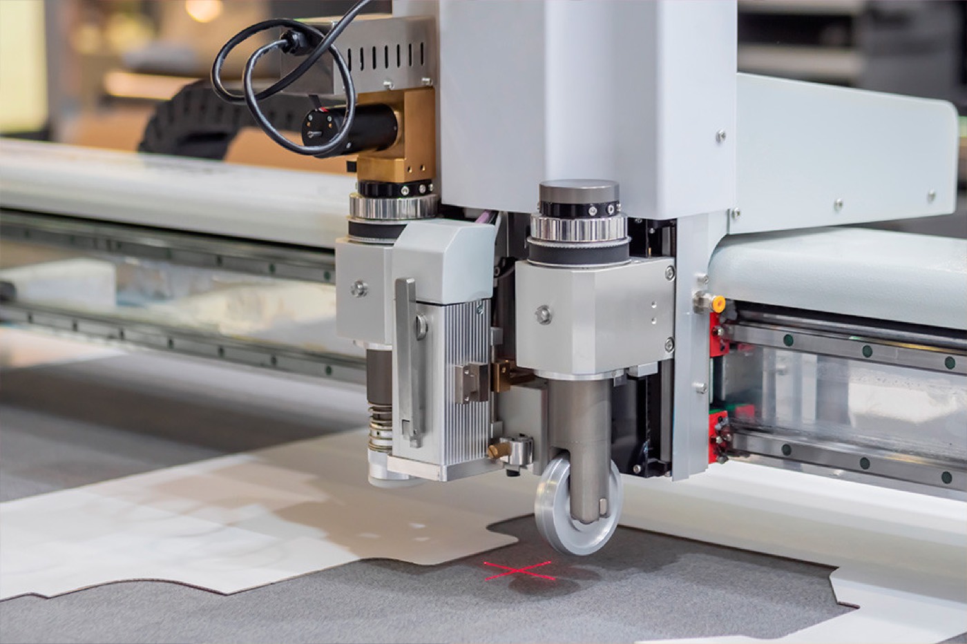 Digital flatbed knife cutter working across a printed board in the Platinum Signs workshop
