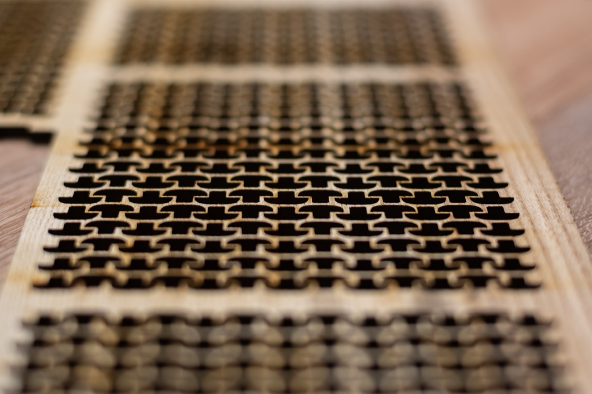 Close-up of an interlocking flexible-hinge pattern laser cut through a timber panel