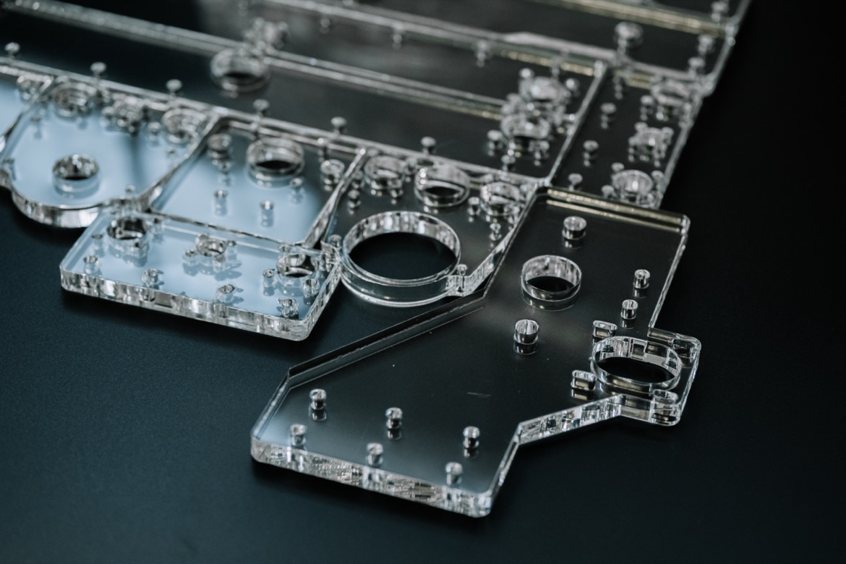 Stacked clear acrylic technical plates with polished edges and precise cut-outs