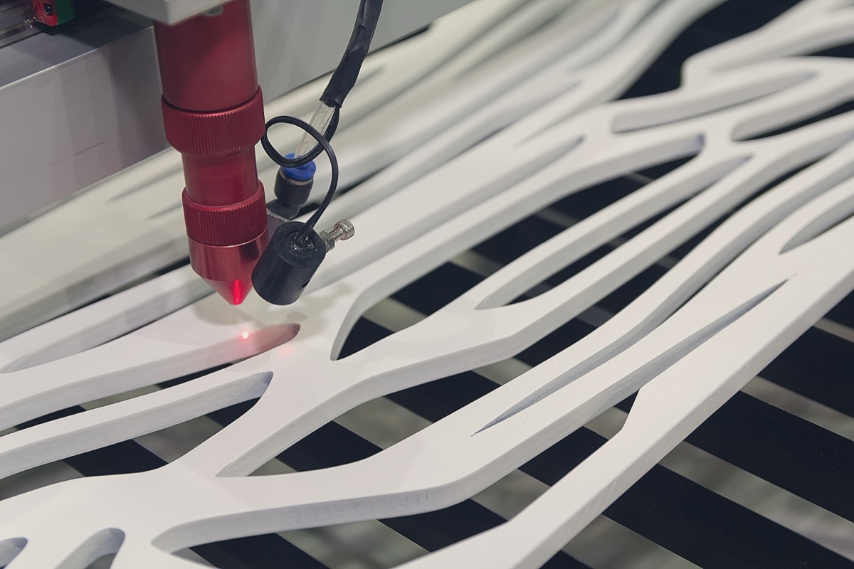 CO2 laser cutting an organic flowing pattern from white acrylic sheet