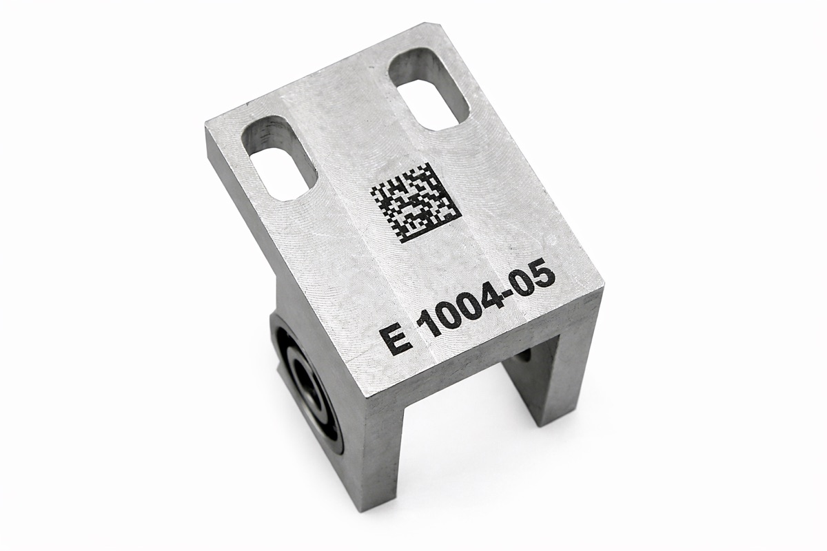 Machined bracket marked with part number and data-matrix code