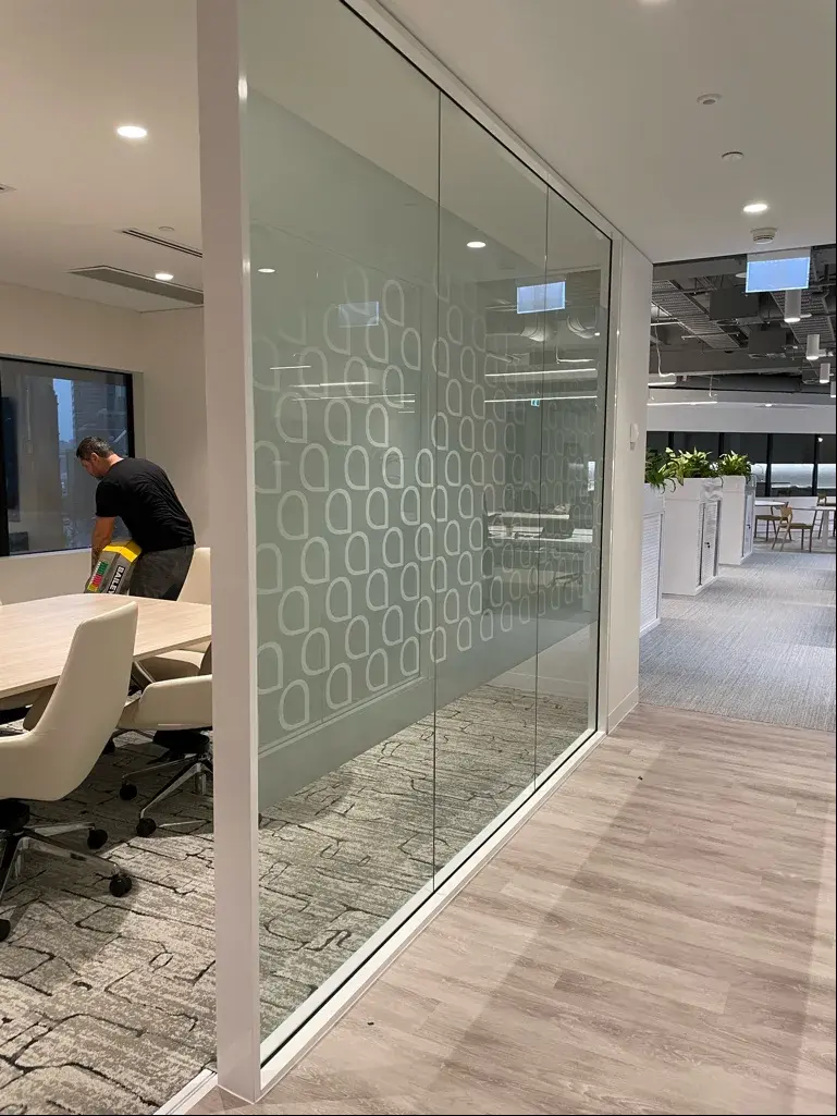 Boardroom glazing recorded during the Aramco printed frost-film installation stage