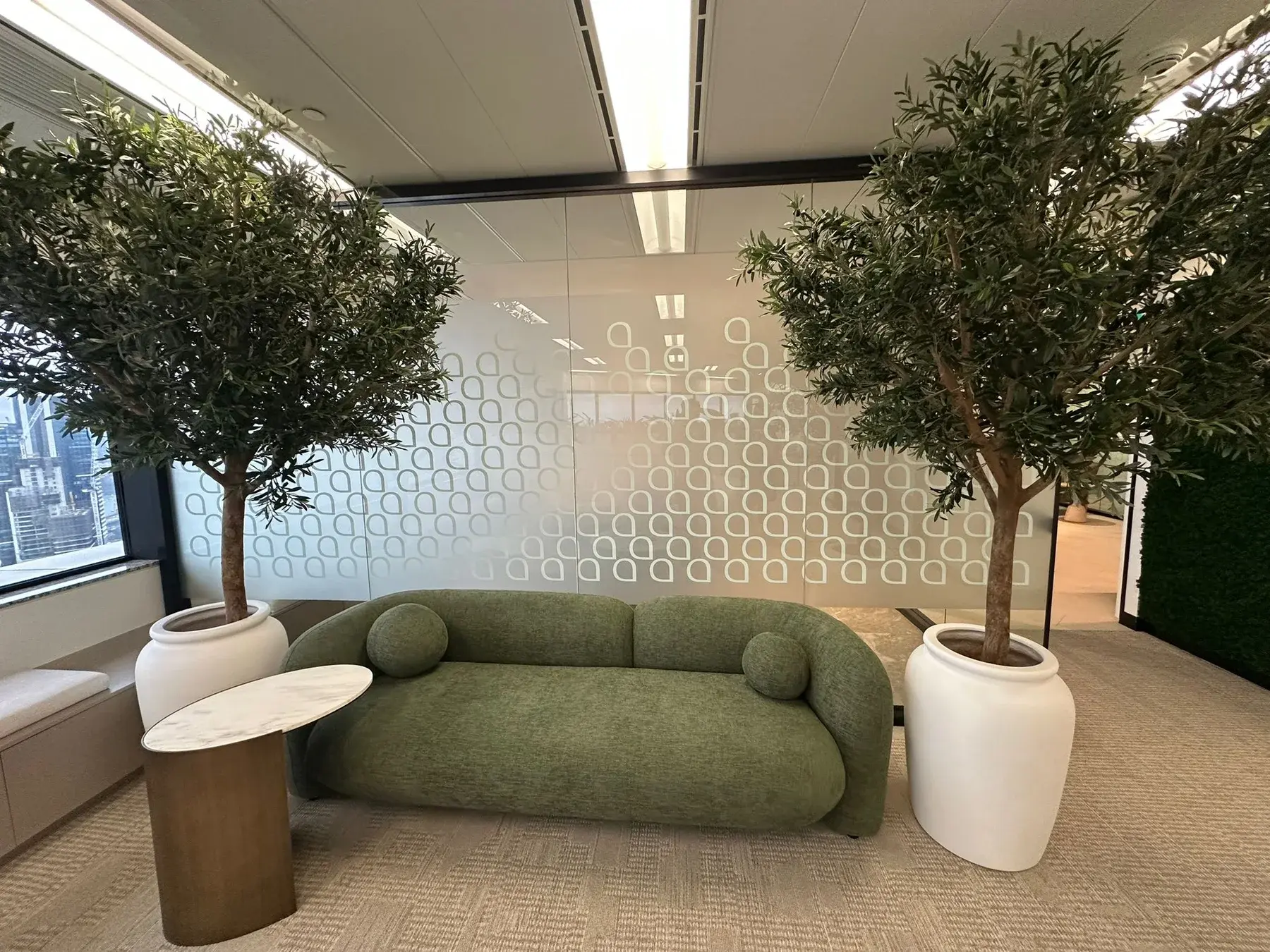 Finished Aramco lounge area with green seating and patterned privacy film on the glass behind