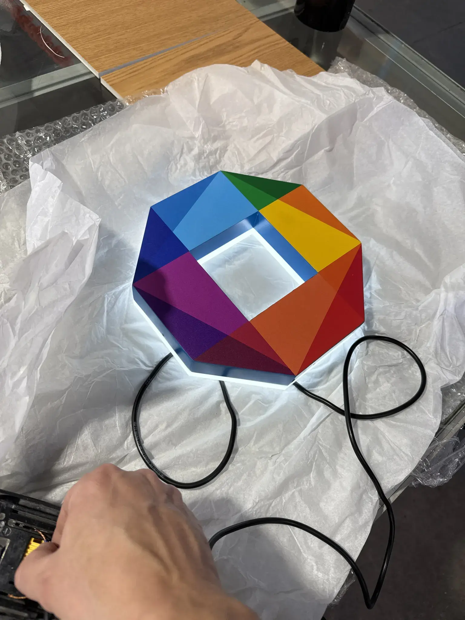Multicolour dimensional BYRONS emblem illuminated during quality control before protective packing