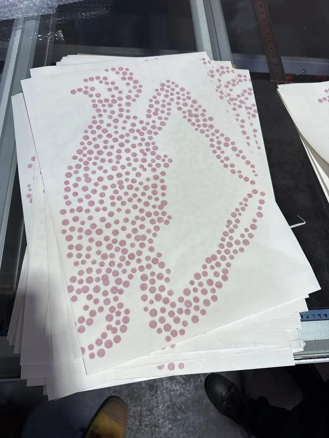 Stack of printed crab motif graphics produced for the mosaic tile band, in halftone dot pattern