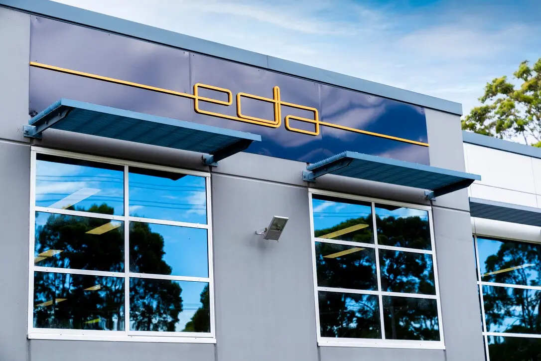 Completed EDA façade in Sydney with a yellow dimensional PVC logo mounted across gloss-black ACM panels