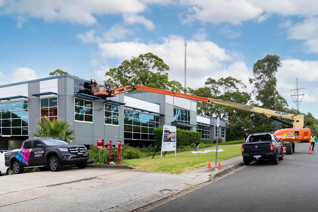 Platinum Signs vehicles and a boom lift set up outside the Sydney commercial building