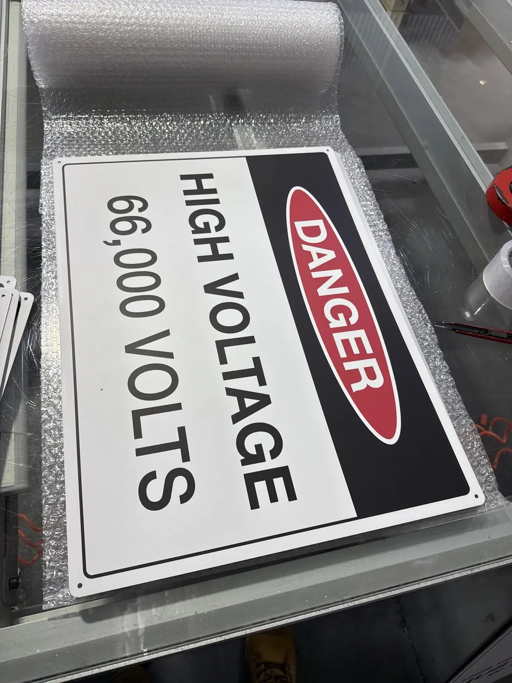 Danger high voltage 66,000 volts aluminium safety sign finished on the workbench before packing