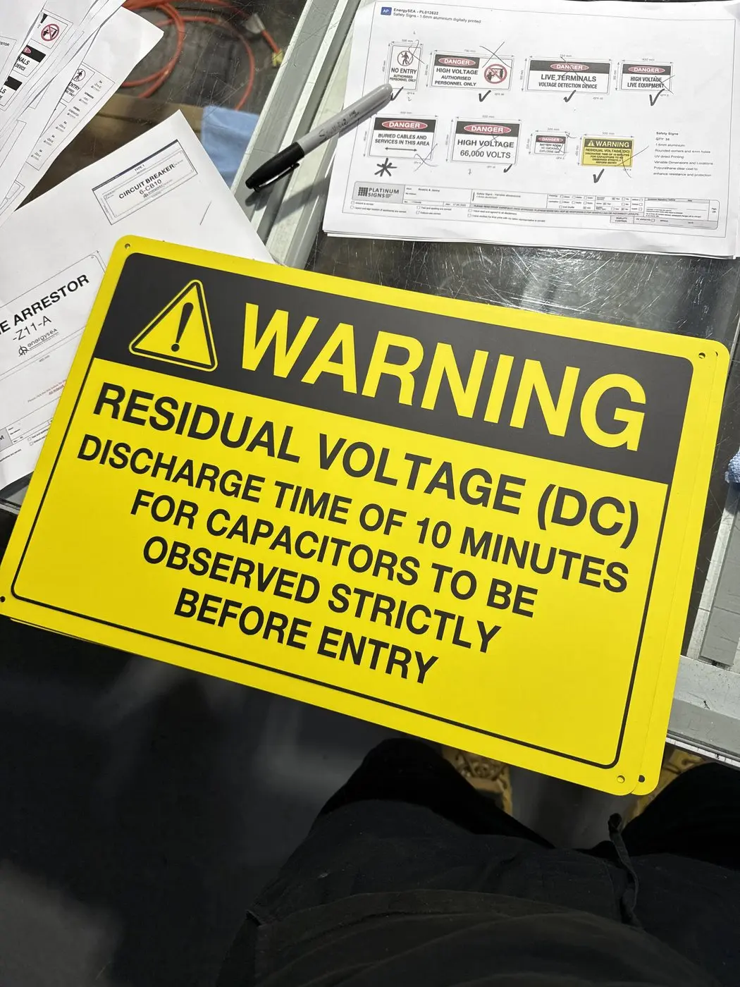 Yellow residual voltage DC warning sign specifying the ten-minute capacitor discharge time before entry