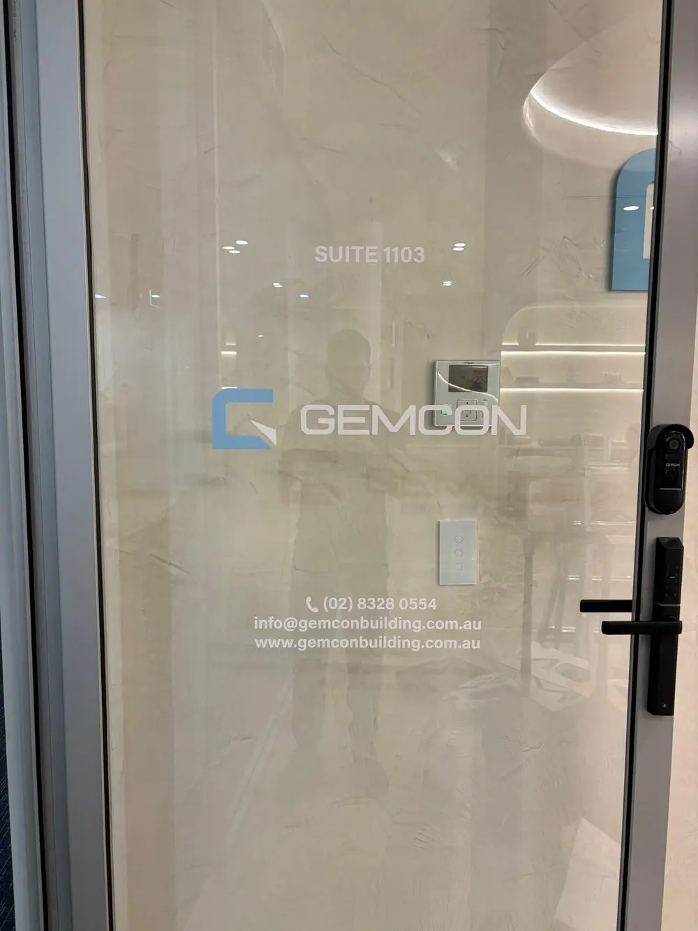 Close view of the digitally printed cut-out window graphic on the glazed GEMCON door showing the logo and printed contact line