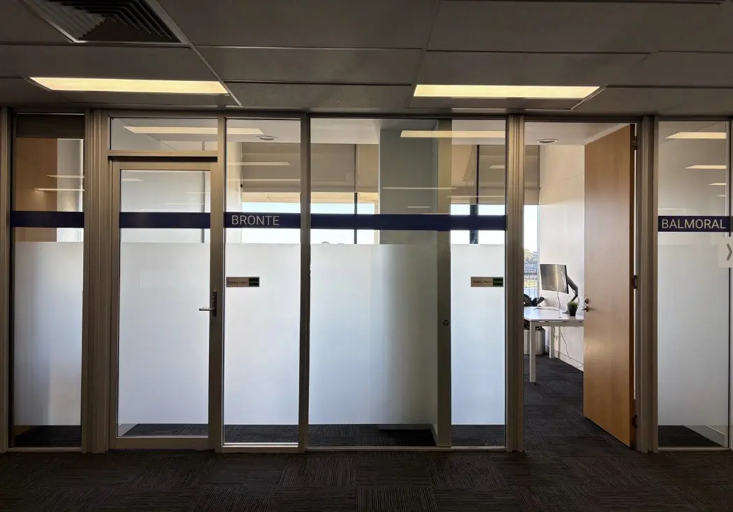 Glazed meeting room partitions with frosted lower panels carrying the room names Bronte and Balmoral on the upper band