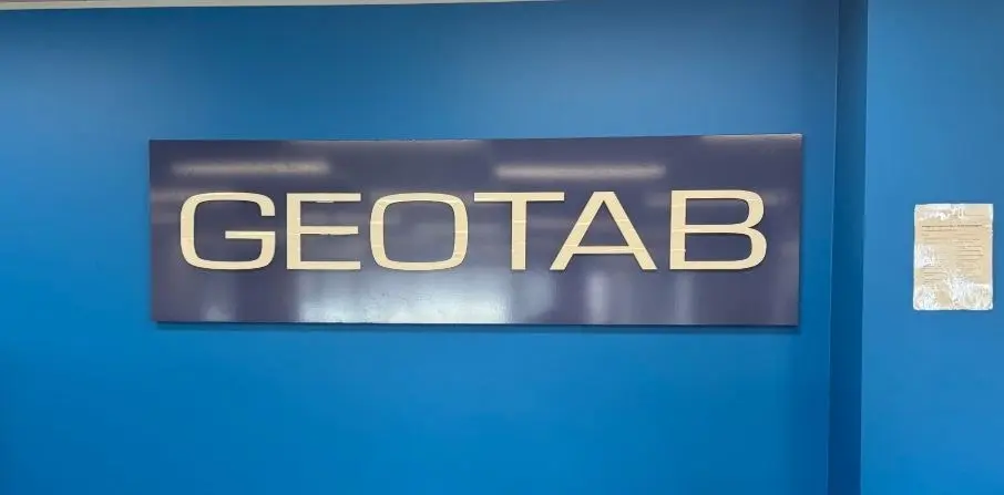 The same Geotab panel photographed in its earlier position against a painted blue feature wall before it was relocated