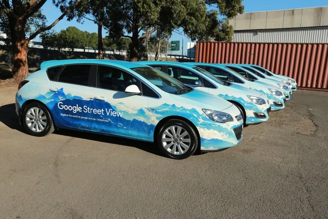 Front three-quarter view down a line of identically wrapped Google Street View vehicles