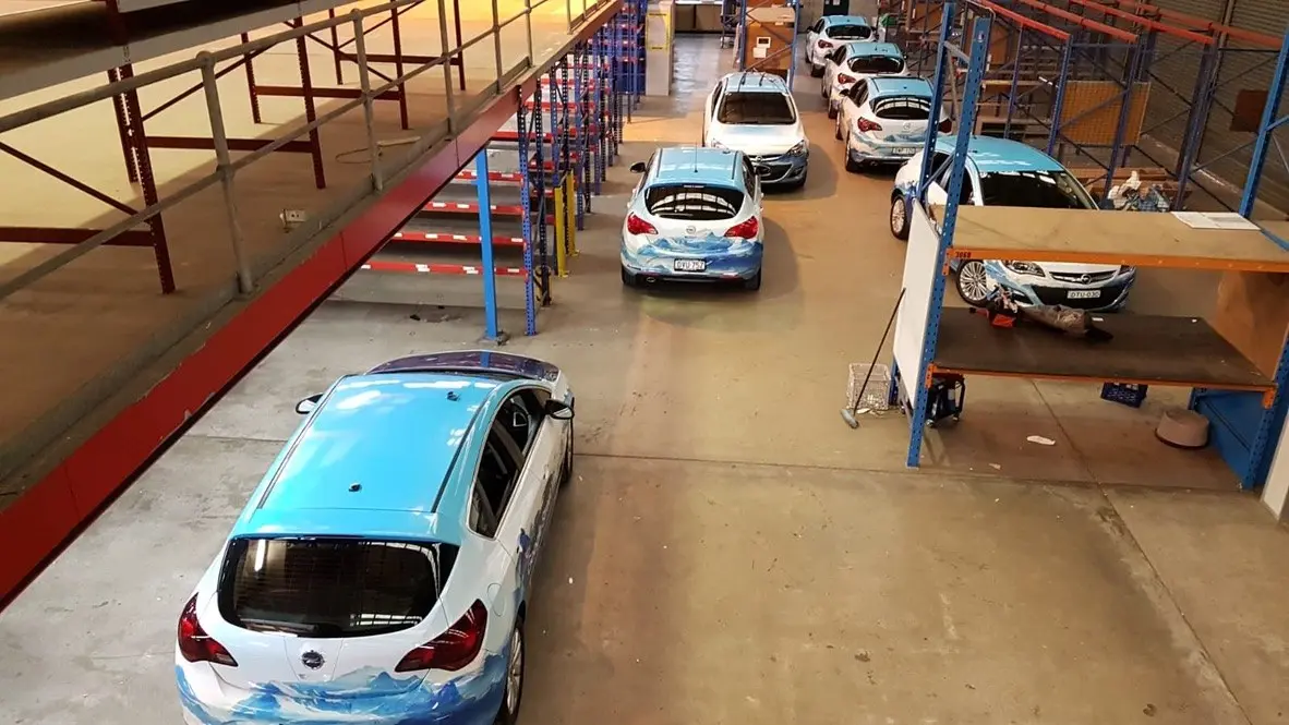 Google Street View vehicles staged through the workshop in sequence during the wrap program
