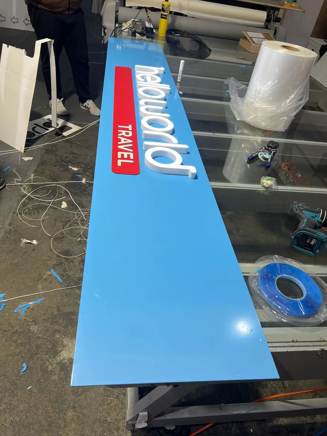 Full blue helloworld Travel panel with face-lit 3D letters laid out on the workbench during assembly