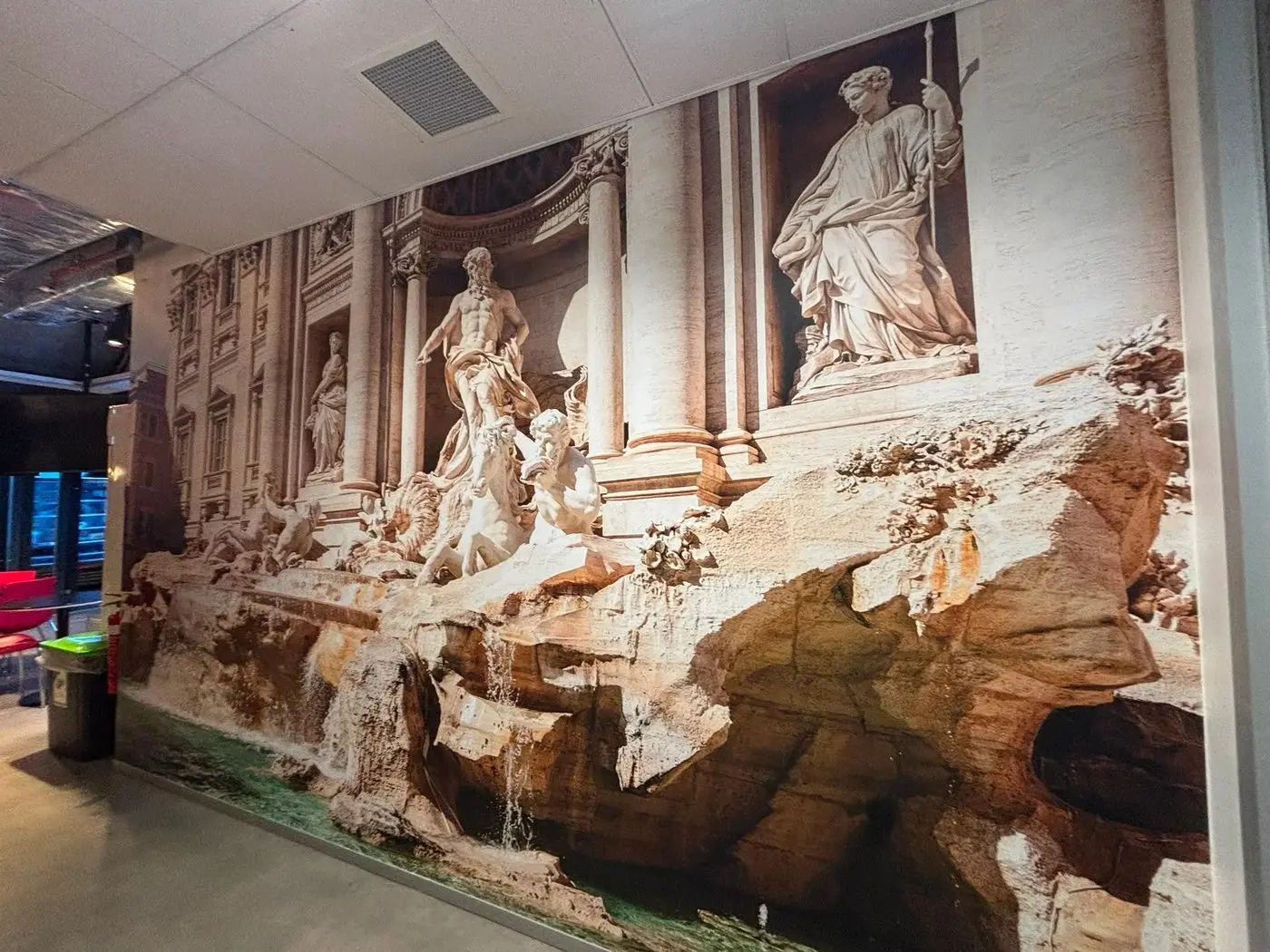 Trevi Fountain mural covering an office wall beside a glazed meeting room