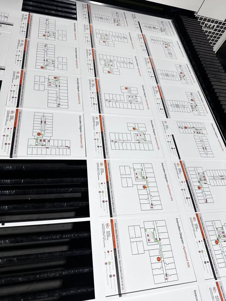 Sheets of UV-printed evacuation diagrams for different apartments laid out together before separation