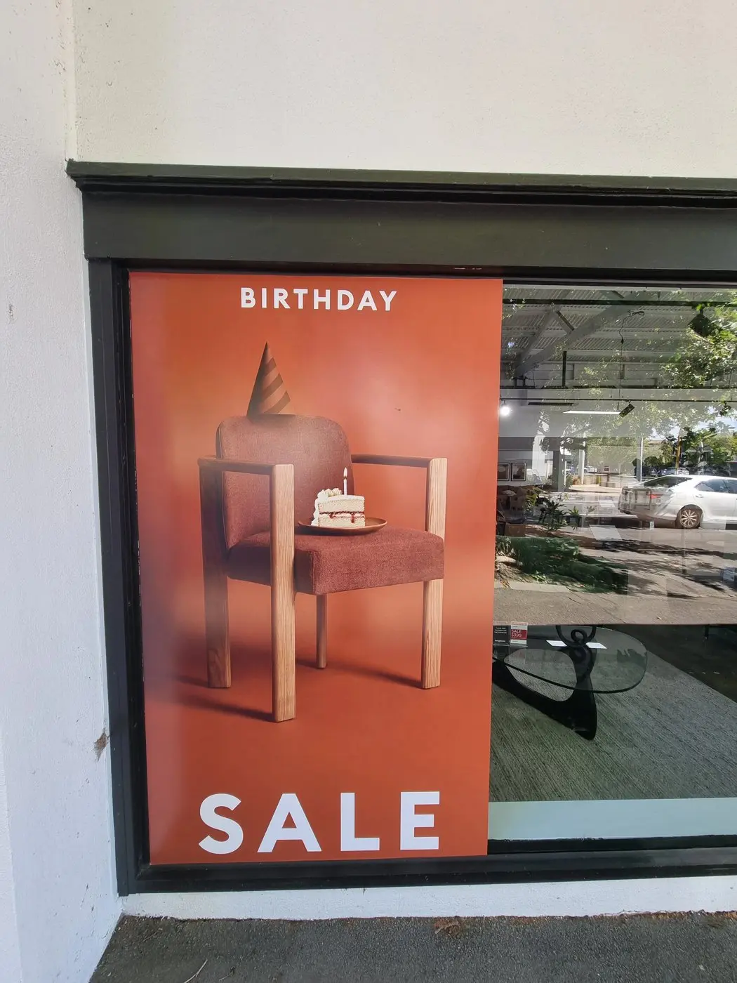 Close view of the Birthday Sale panel artwork showing a chair with a birthday cake and party-hat illustration
