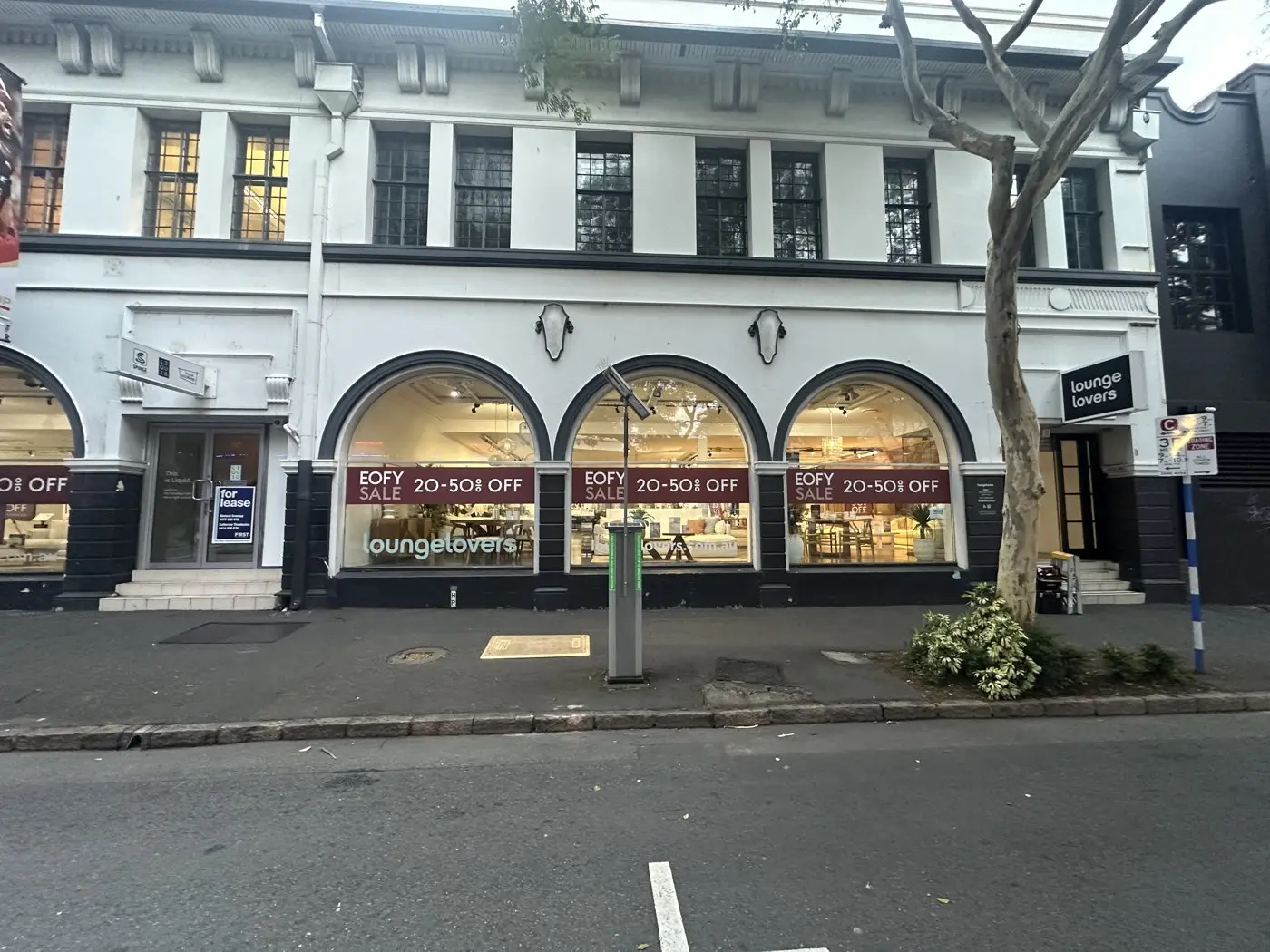 Lounge Lovers heritage showroom frontage with EOFY sale window graphics running through every arched window