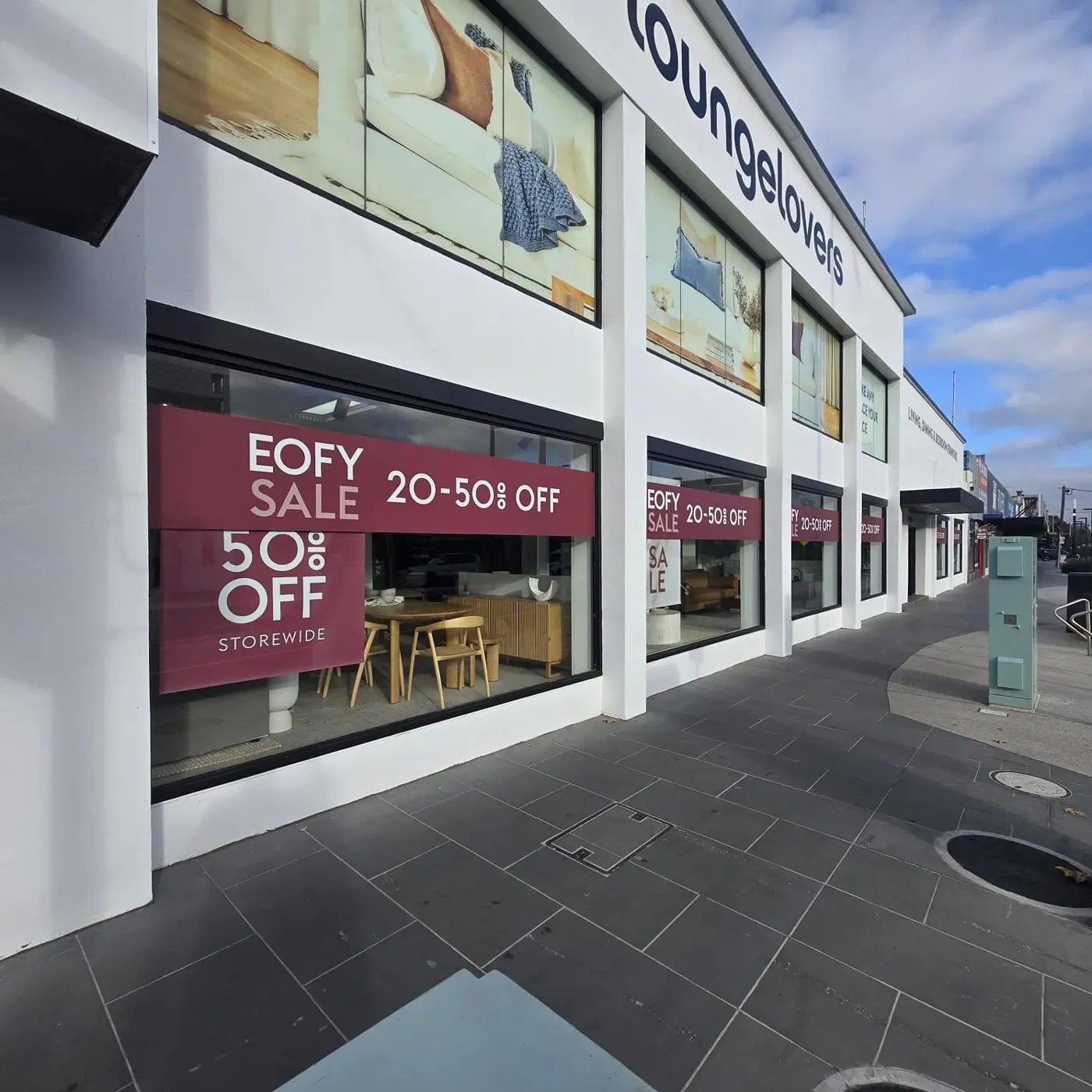 Close angle of an EOFY sale 20 to 50 percent off window banner on a showroom frontage
