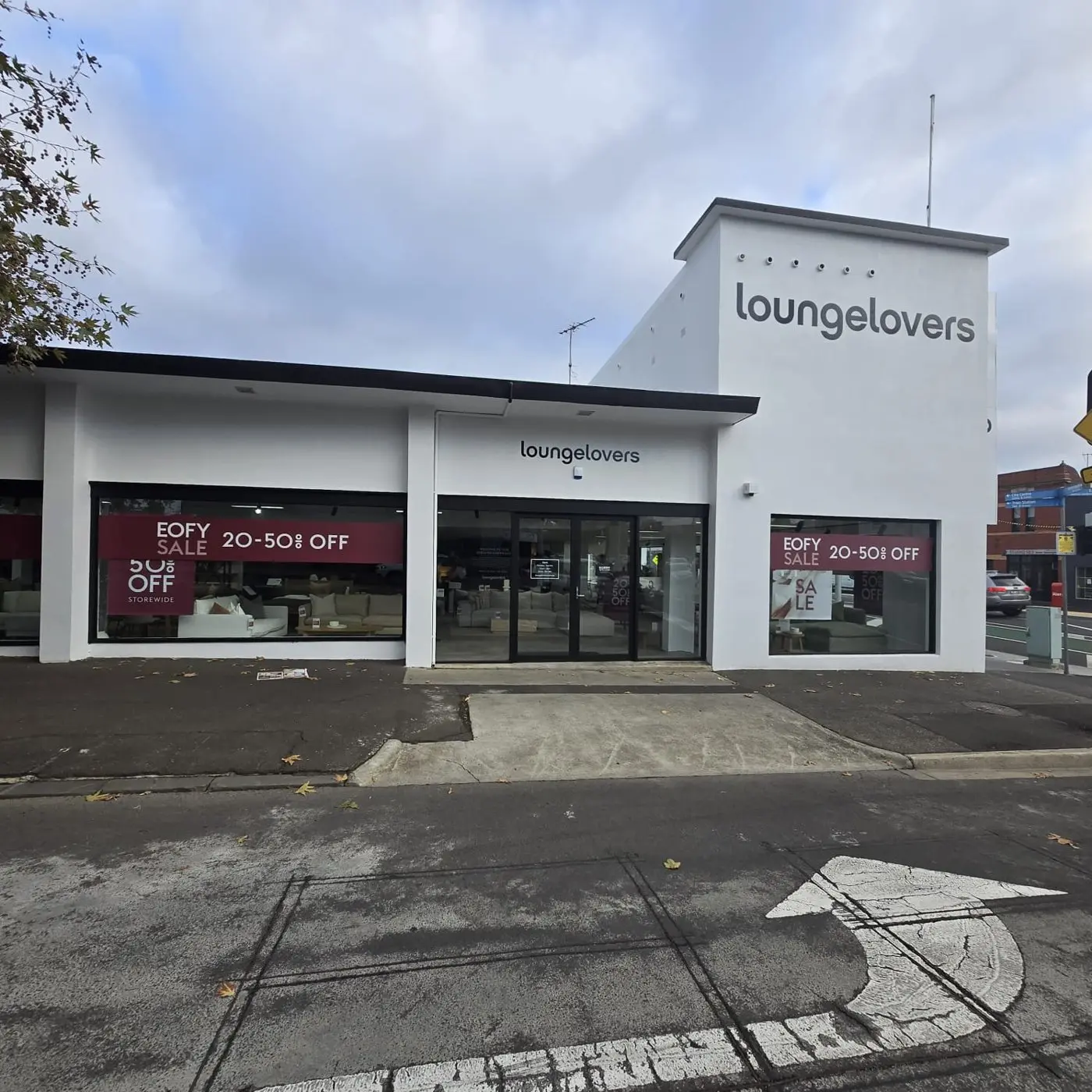 Full Lounge Lovers showroom building with EOFY sale banners running across its window line