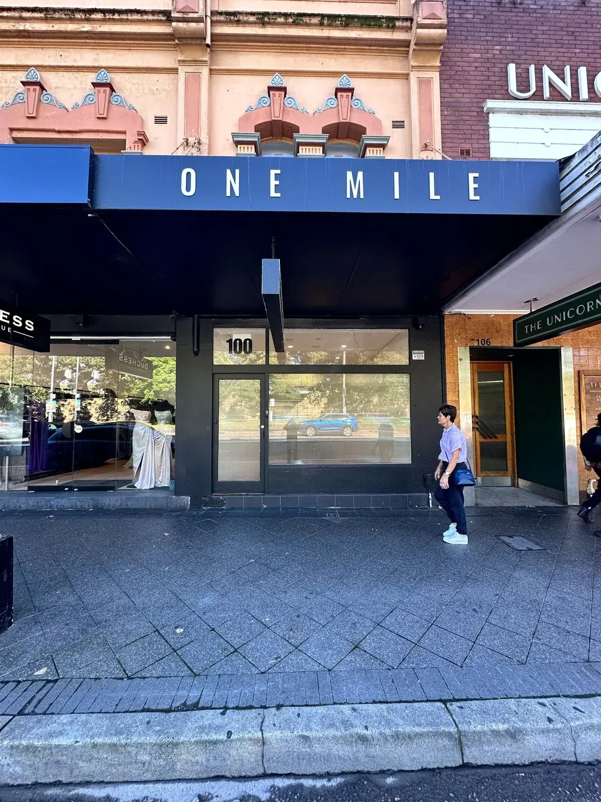 ONE MILE dimensional letters spaced across the dark Oxford Street fascia at the Paddington boutique
