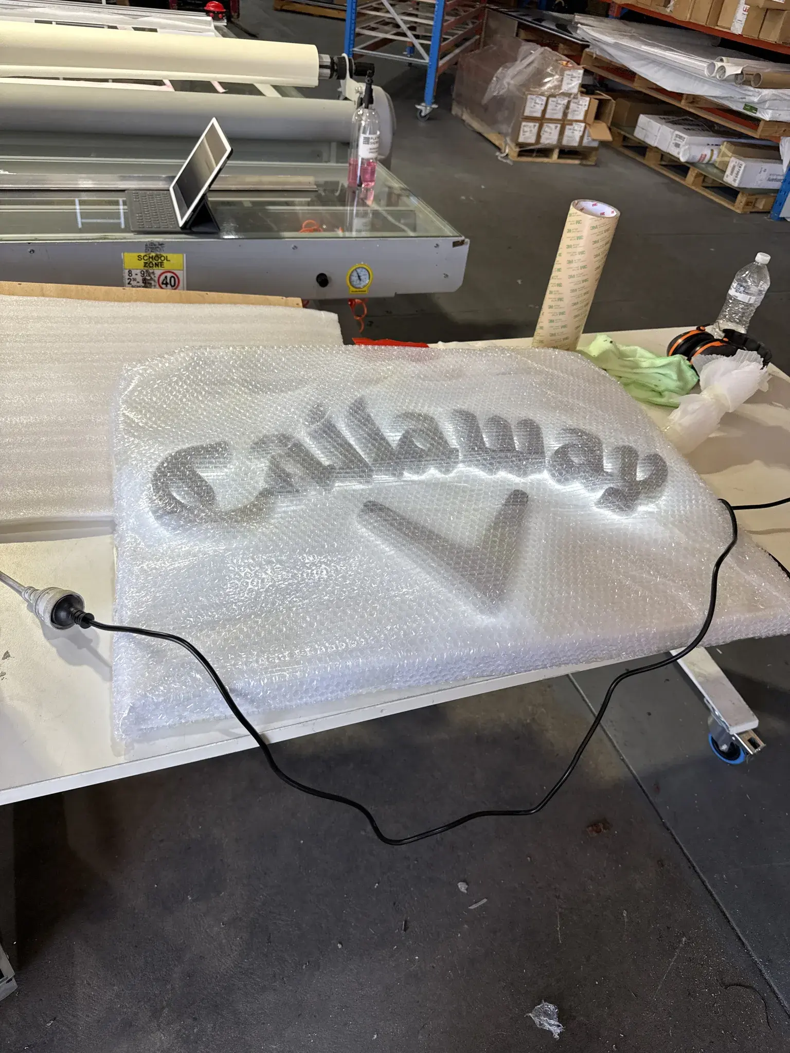 Callaway illuminated script lettering wrapped for protection during production, with the LED wiring visible