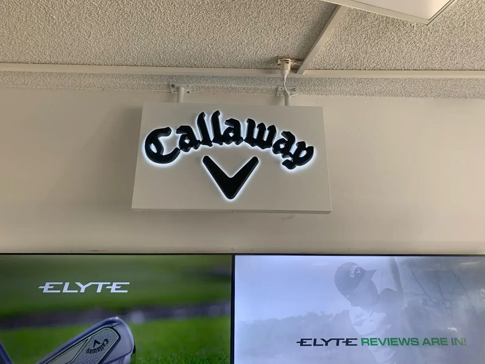 Suspended illuminated Callaway sign marking the brand's department below the ceiling line