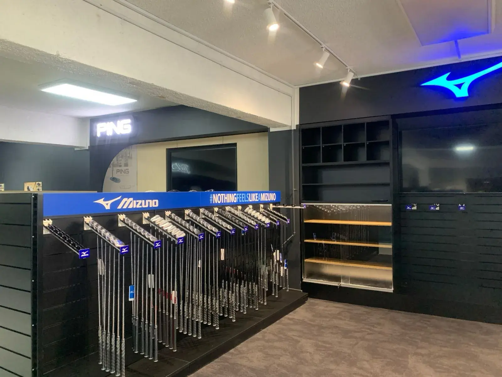 PING sign and Mizuno branding across the neighbouring club fitting bays