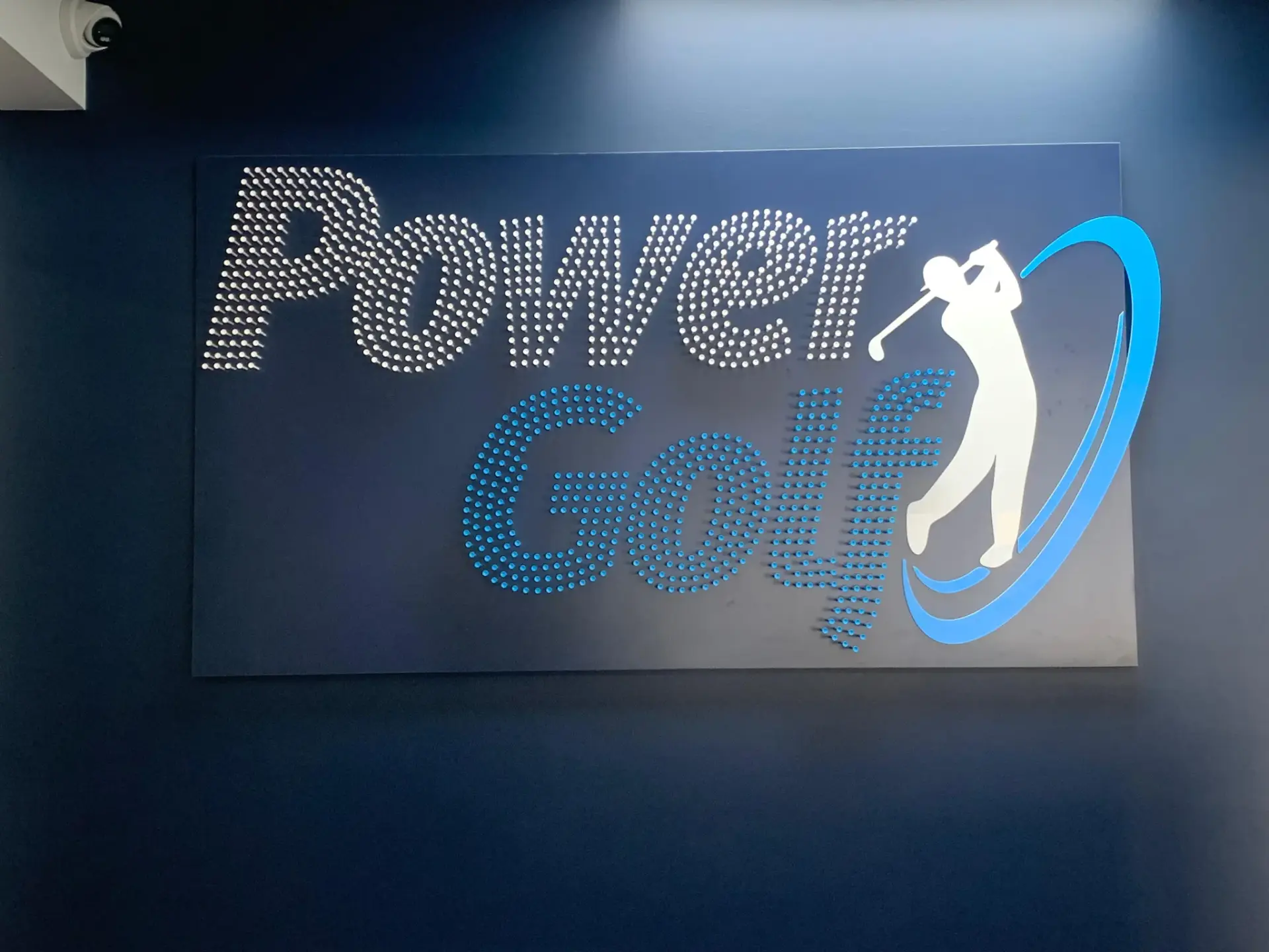 Power Golf feature sign rendered in a dot pattern with the swing figure on the dark interior wall
