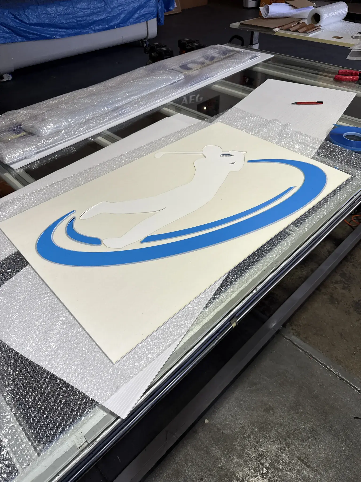 Power Golf swing-figure logo panel wrapped and staged in the workshop before delivery
