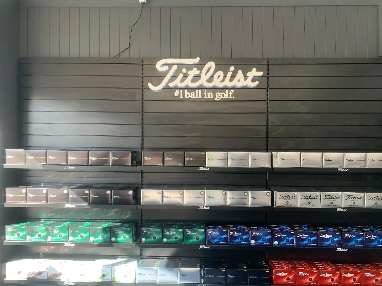 Titleist brand panel lettering mounted above the merchandised golf ball display bays