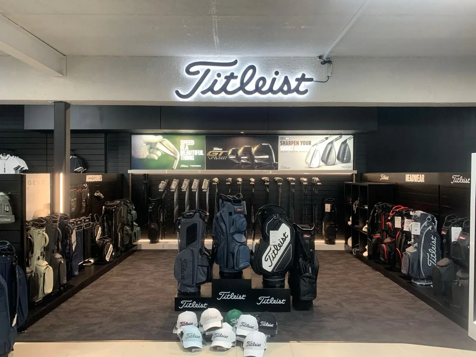 Illuminated Titleist sign above the completed bag and club fitting department