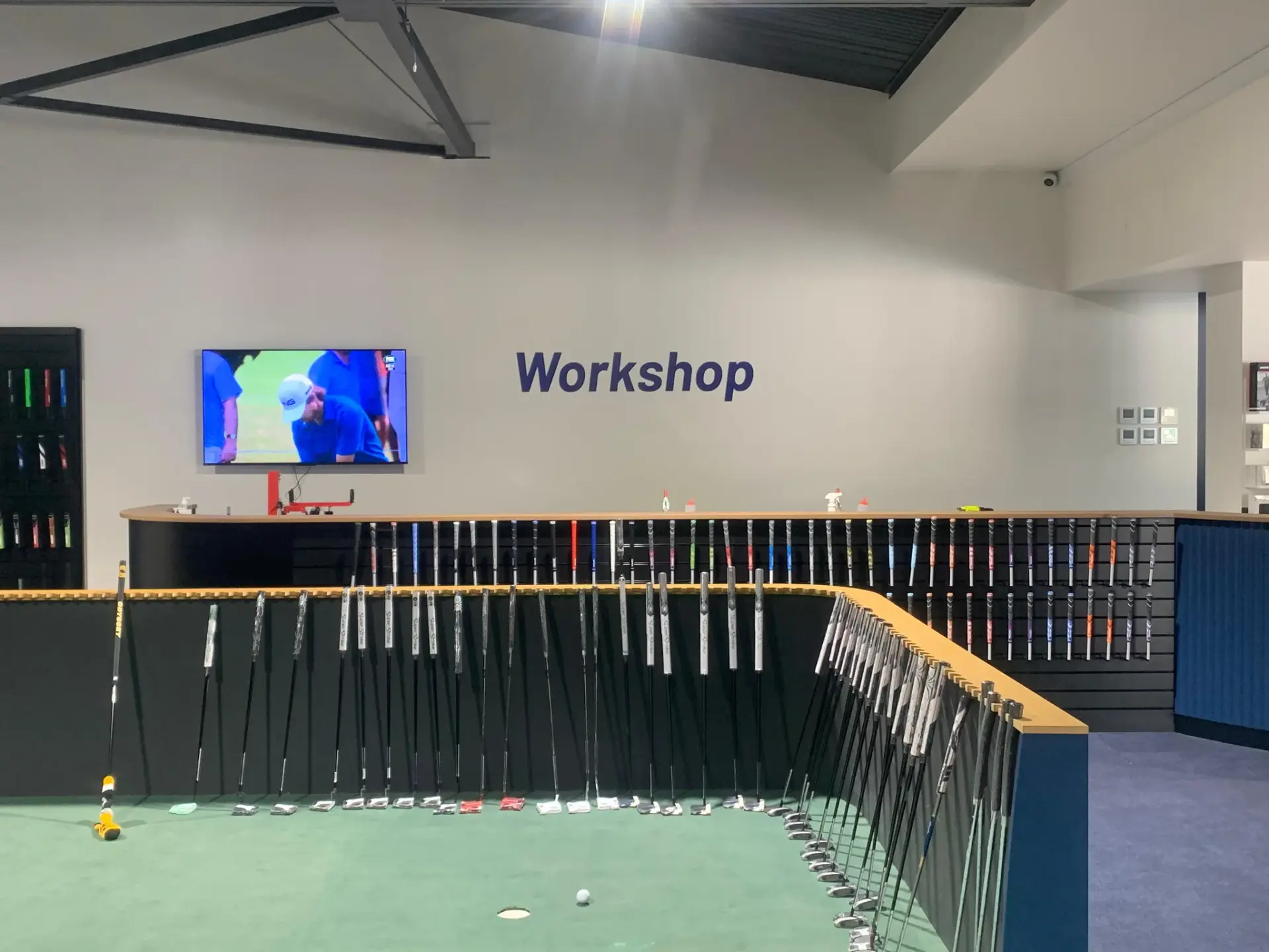 Workshop wall lettering installed above the club repair benches and grip fitting area