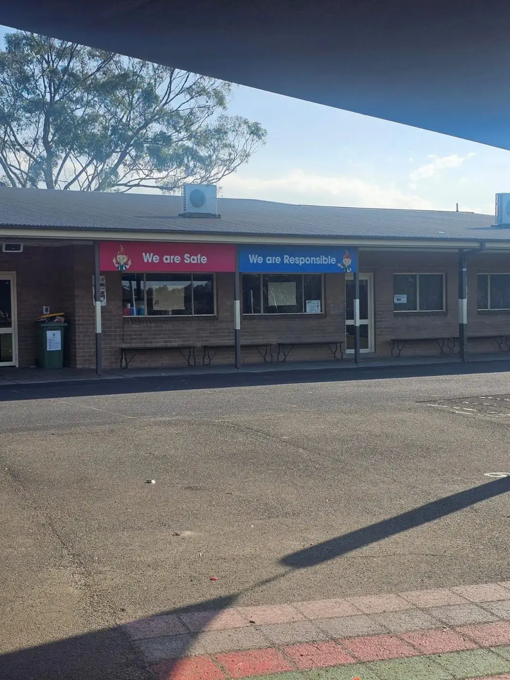 School building frontage with We are Safe and We are Responsible values panels mounted along the fascia
