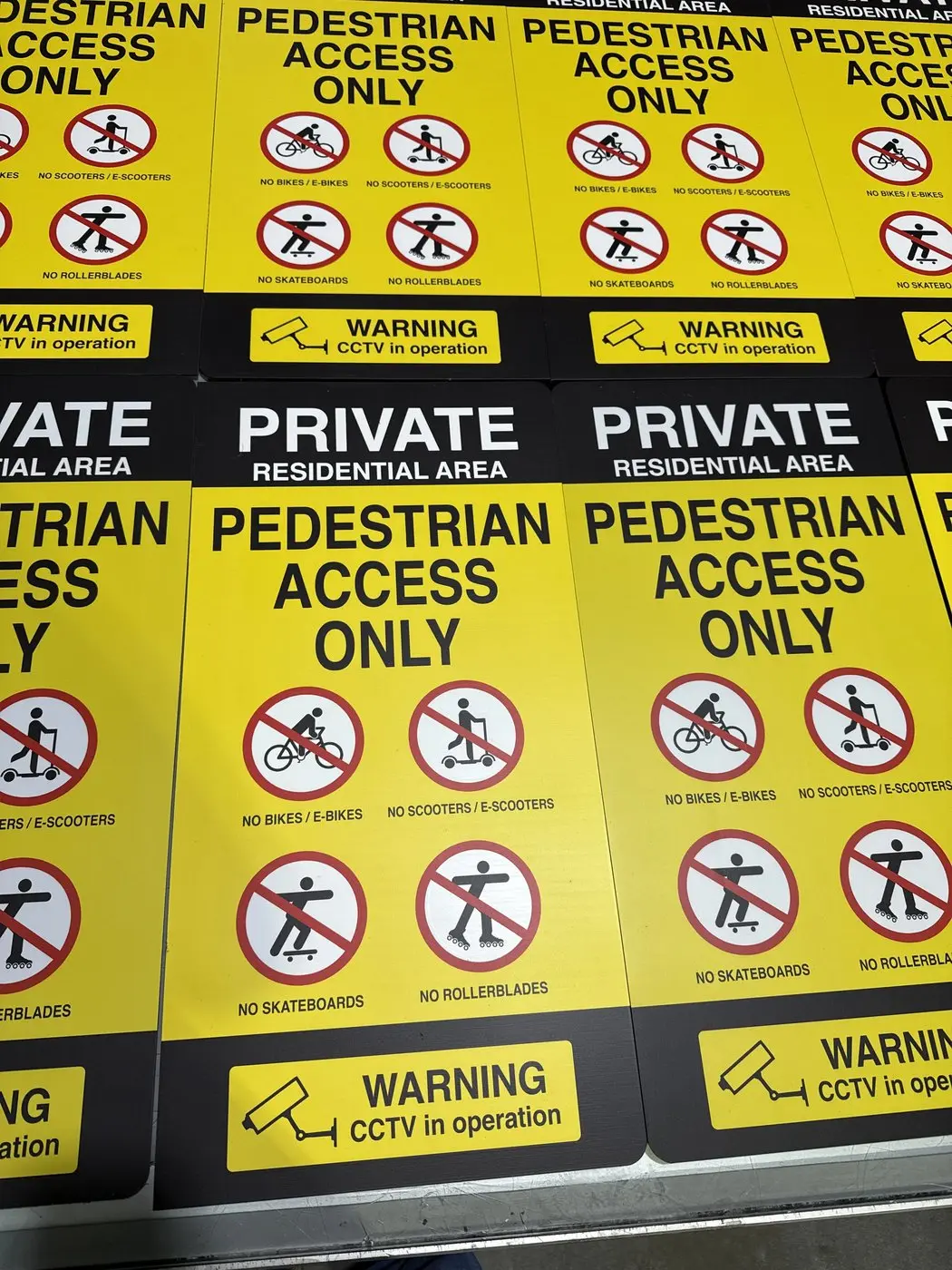 Rows of yellow pedestrian access only panels with CCTV warning strips laid out in production
