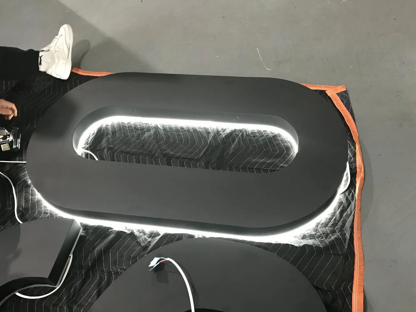 Single large letter O powered up during quality checks, its halo LEDs glowing white around the letter edge
