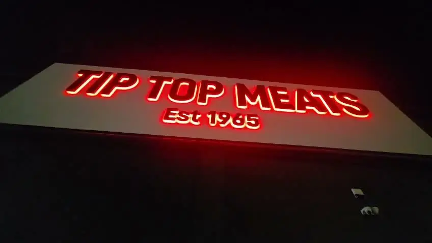 Tip Top Meats Est 1965 halo-illuminated 3D letters glowing red at night on the Laverton North building