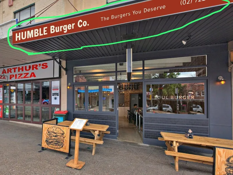 Humble Burger fascia with green illuminated outline above the restaurant entrance.