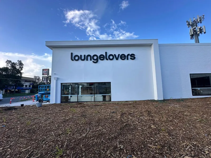 Black Lounge Lovers letters on a white retail frontage.