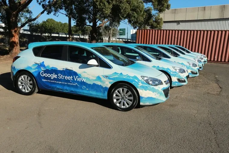 Front three-quarter view down a line of identically wrapped Google Street View vehicles